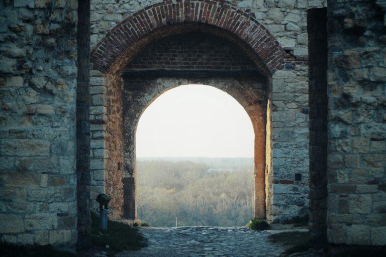 brown brick arch near body of water during daytime
